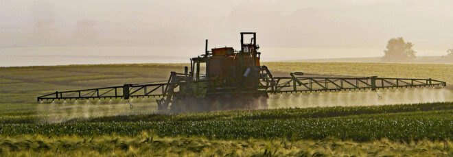 tractor spraying farm fields with herbicide