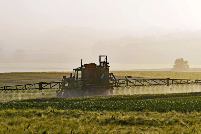 tractor spraying farm fields with herbicide