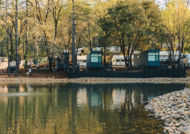 group of black cabins on waters edge