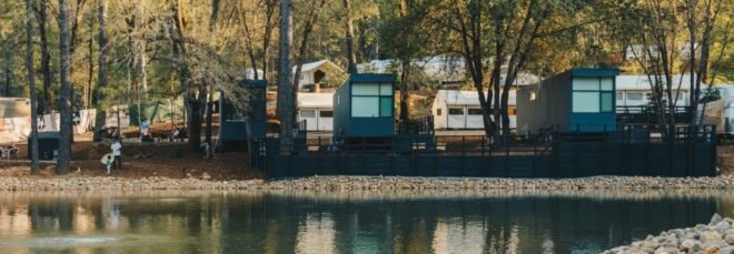 group of black cabins on waters edge