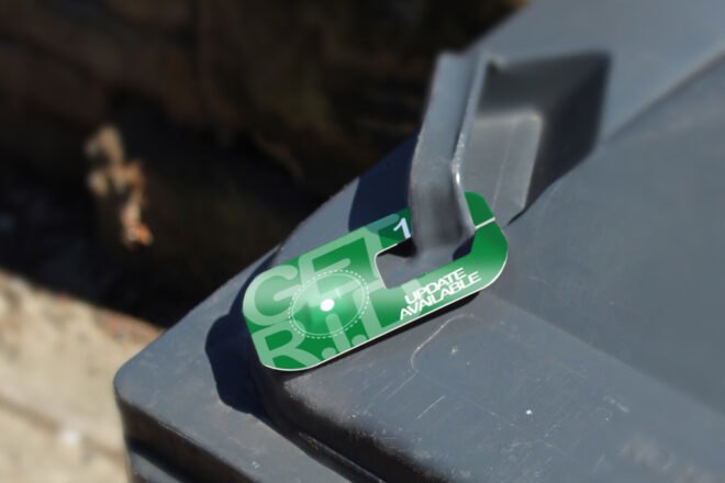 green tag attached to a garbage bin