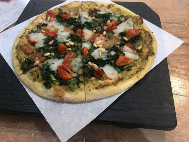 pizza with tomato, pesto and pine nuts