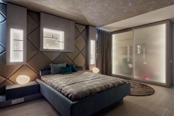 gray bed in gray bedroom with recessed lighting