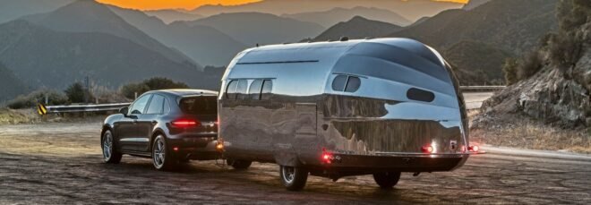 aluminum-clad camper being towed by SUV