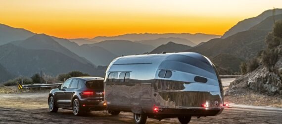 aluminum-clad camper being towed by SUV