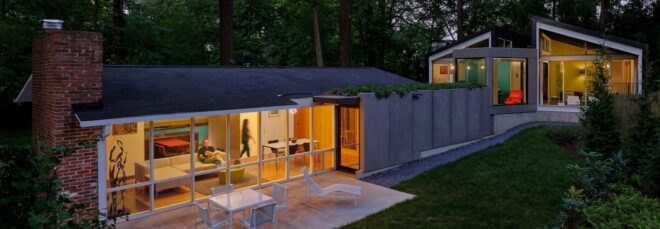 elongated home with angular volumes lit up at dusk