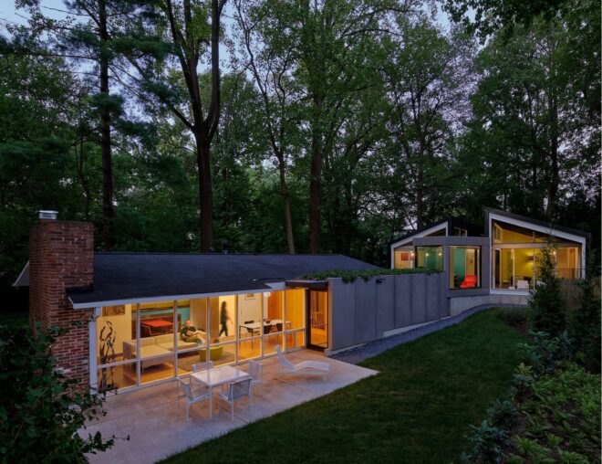 elongated home with angular volumes lit up at dusk