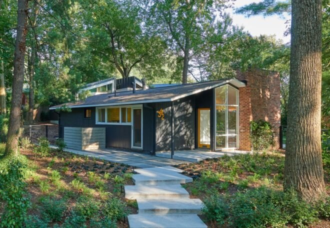 dark gray midcentury home with pitched roof