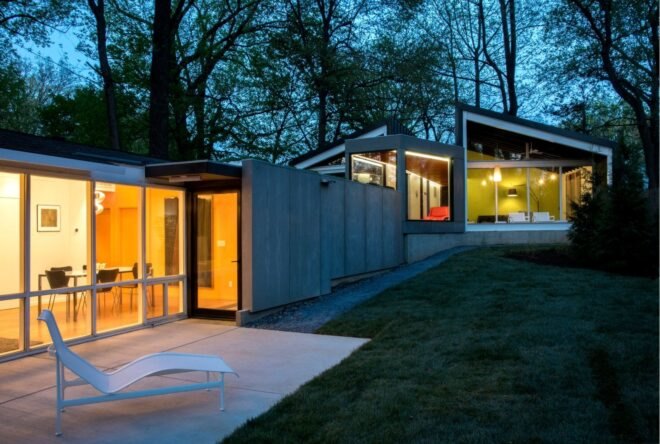 low-lying home lit from within at dusk
