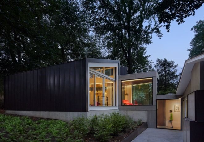 home with dark exterior and a glass wall