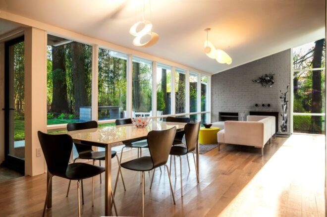 wood dining table and black chairs in room with glass walls
