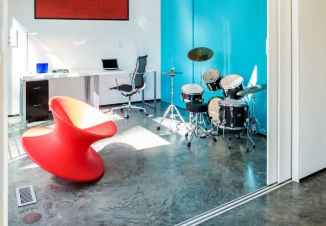 music room with blue walls, red chairs and a drum set