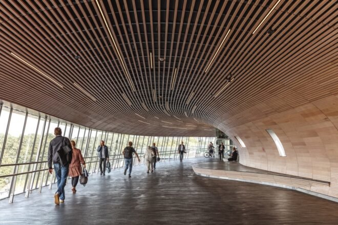 people walking through wood-lined tube