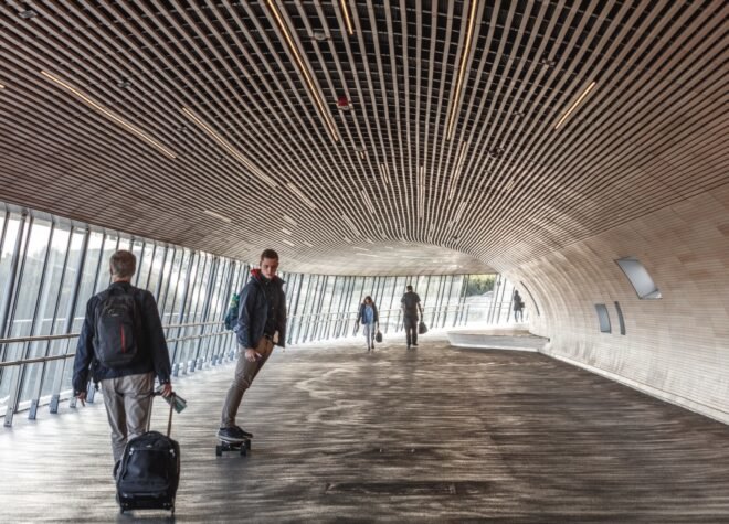 people skateboarding and walking through tube-like bridge