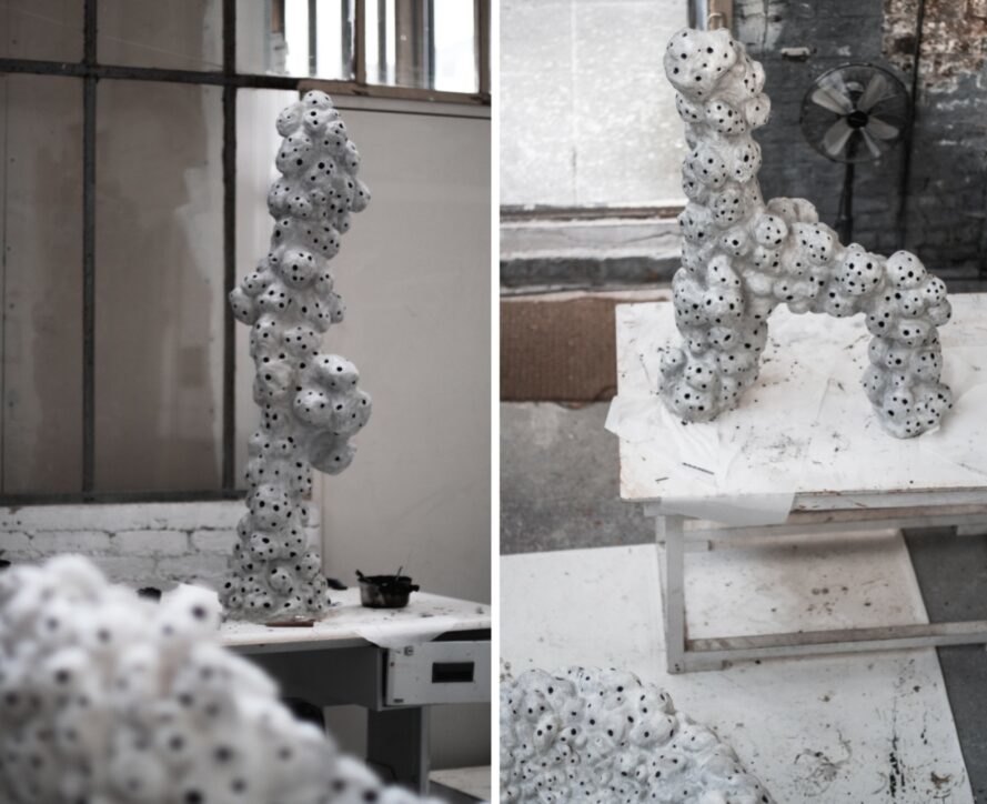 white sculptures with holes on display