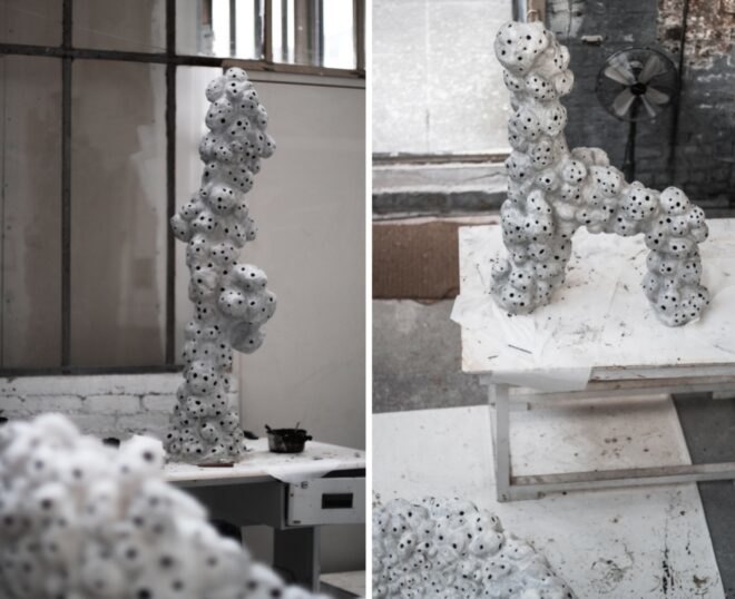 white sculptures with holes on display