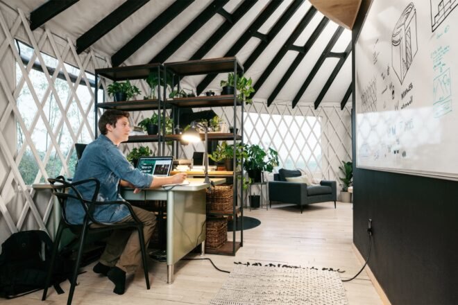 person working at plant-covered desk