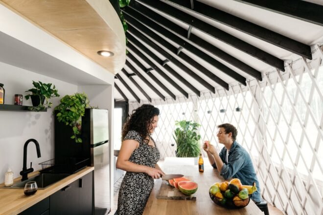 couple preparing food in a kitchen with dark cabinets and wood countertops