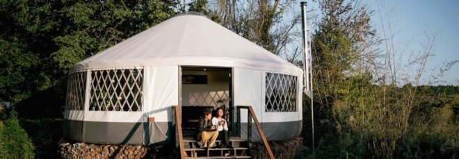 couple sitting on steps outside yurt home