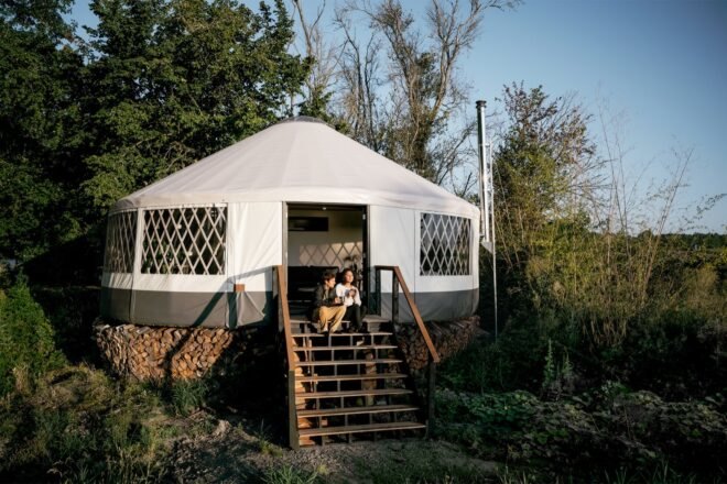 couple sitting on steps outside yurt home