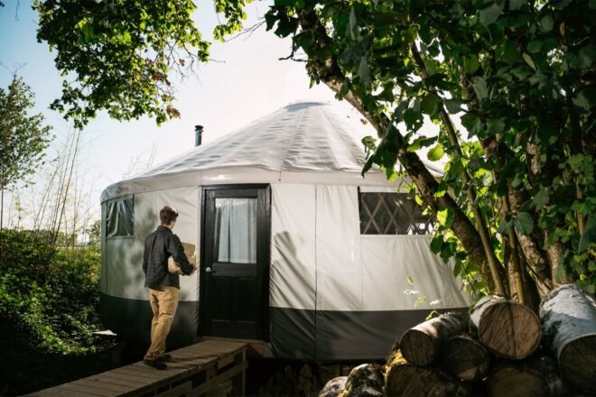 person walking to door of a yurt home
