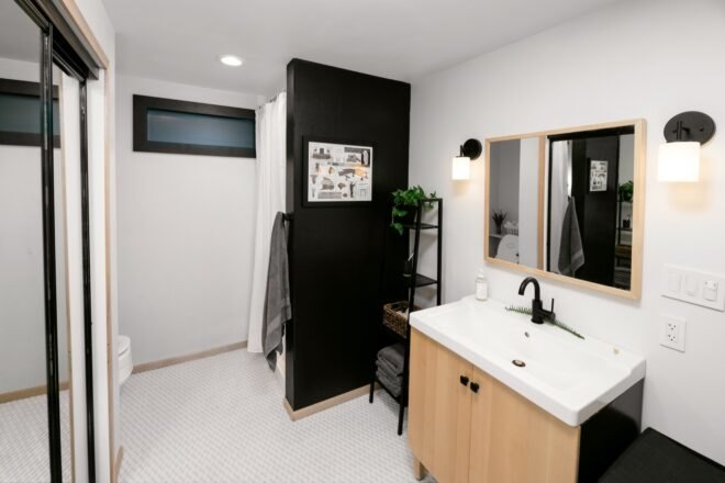 bathroom with black shower and wood vanity
