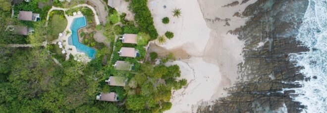 aerial shot of beach front hotel bungalows and swimming pool