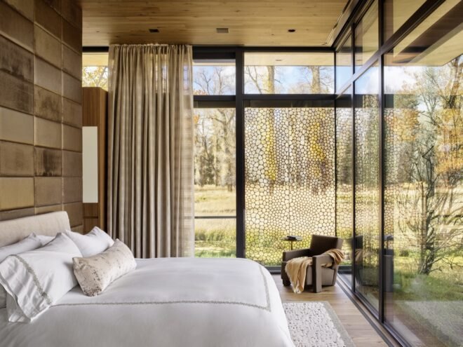 bedroom with large floor to ceiling windows and white bed spreads
