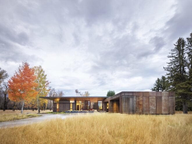 single story home with wooden facade surround by trees and waterways