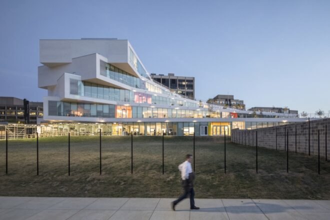 white building with staggered exterior lit up at night