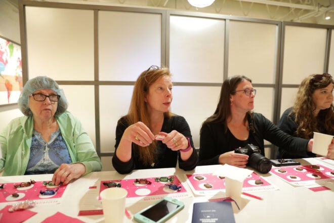 Inhabitat author Teresa Bergen in middle tasting vegan chocolates
