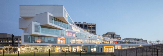white building with staggered exterior lit up at night