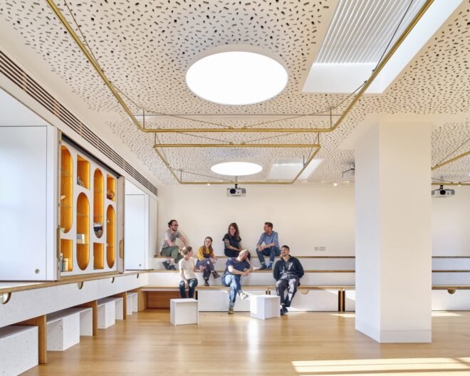 people sitting on white benches in a large white room