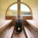 interior of oval-shaped wooden sauna with wood-burning stove