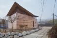 small tan home with butterfly roof