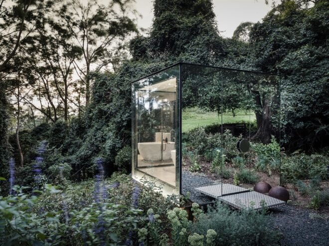 side view of small mirrored building in a forest