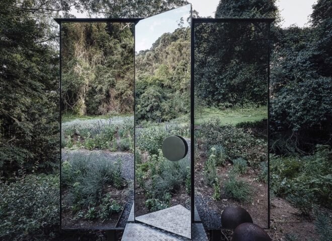mirrored door opening to a mirrored building in a forest