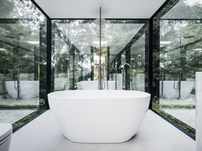 white free-standing tub in small room with glass walls