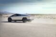 gray electric truck driving on a dusty road