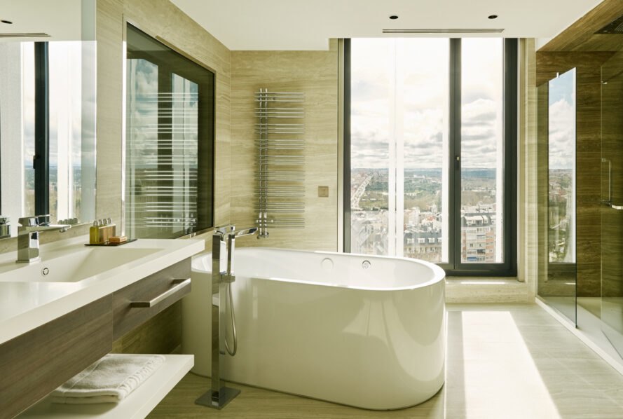 hotel bathroom with free-standing tub near a window