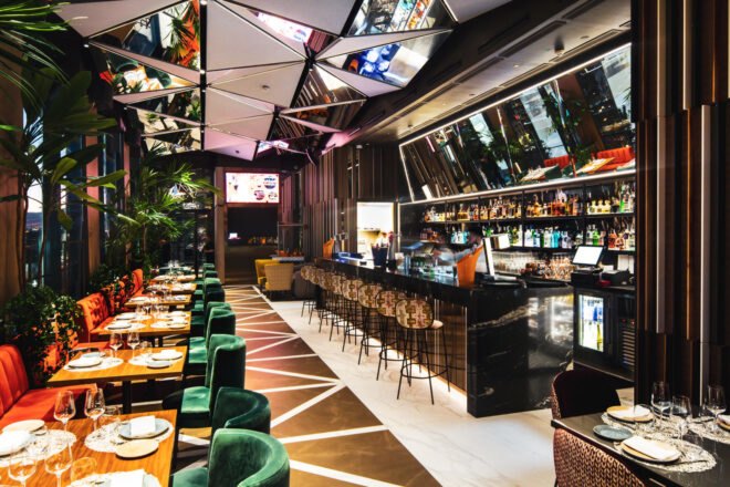 restaurant with geometric floors and ceilings and a long, dark bar area