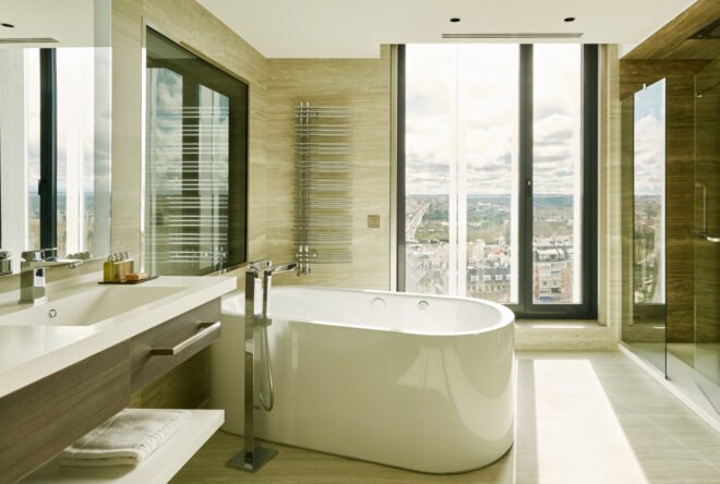hotel bathroom with free-standing tub near a window