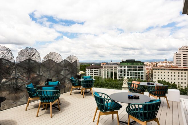 hotel restaurant patio with green chairs and round tables