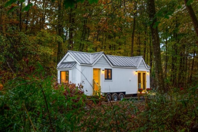 white tiny home on wheels with pitched roof