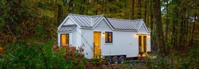 white tiny home on wheels with pitched roof