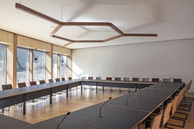 U-shaped black meeting table and chairs in a white room with wood ceiling detail
