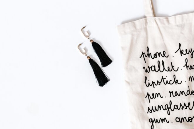 black and white reusable tote next to black tassel earrings