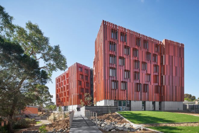 tall wooden apartment building clad in red CLT