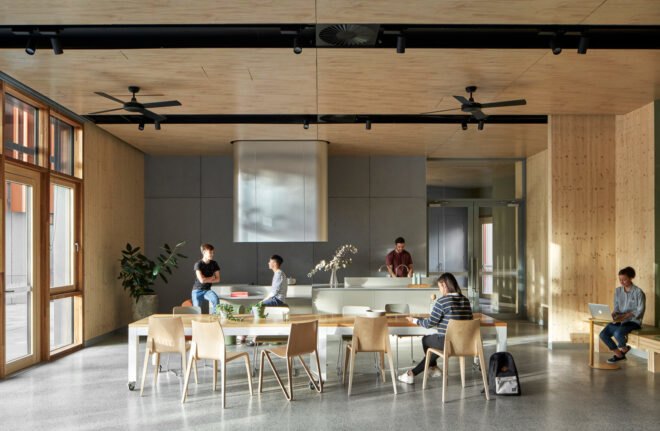 room with wood ceilings, a glass wall and several study tables