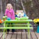 child playing with science craft kit outside at green picnic table